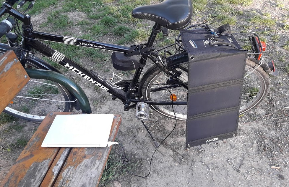Solar panel dangling off a bike, Laptop connected to solar panel